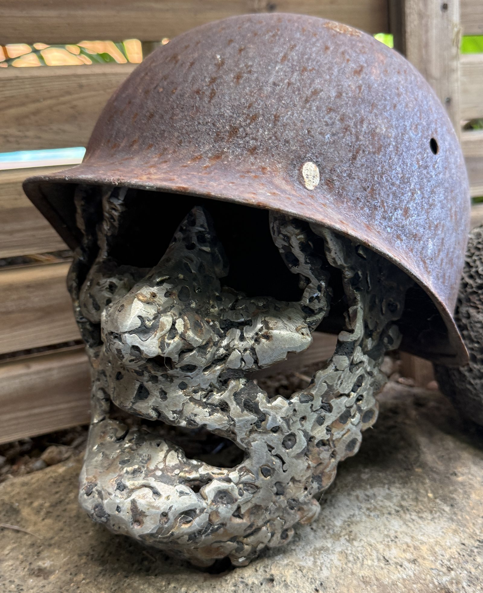 Sculpture de Digema : un crâne de bronze coulé, coiffé d'un casque d'acier